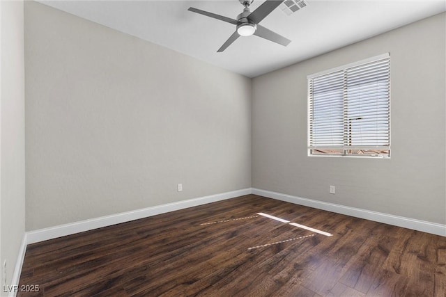 spare room featuring a ceiling fan, dark wood finished floors, visible vents, and baseboards