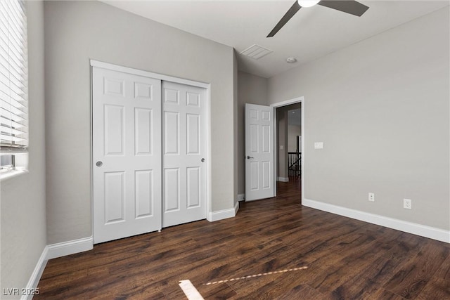 unfurnished bedroom with visible vents, a closet, baseboards, and dark wood-style flooring