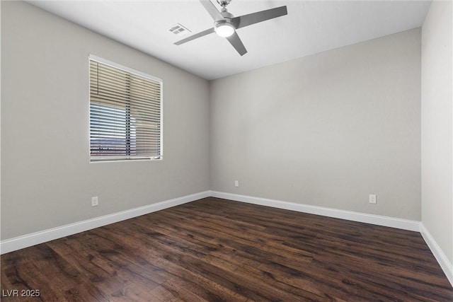 spare room with ceiling fan, dark wood-type flooring, visible vents, and baseboards