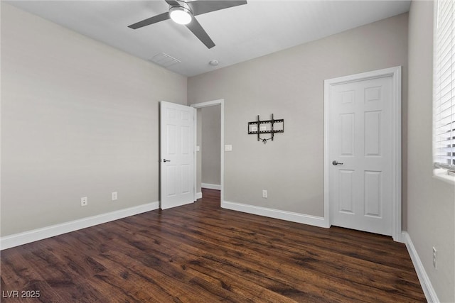 unfurnished bedroom with a ceiling fan, visible vents, baseboards, and dark wood-type flooring