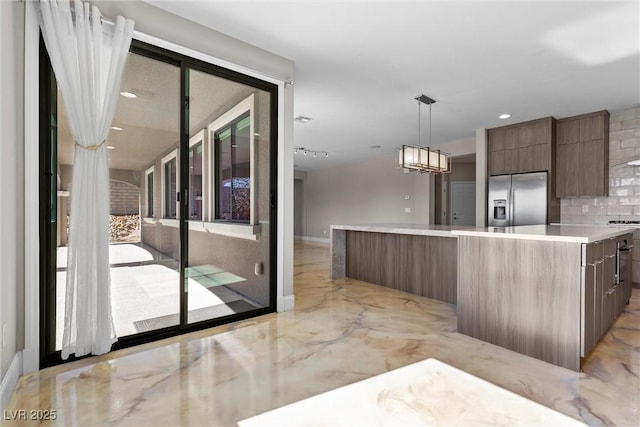 kitchen featuring decorative backsplash, stainless steel fridge with ice dispenser, a spacious island, modern cabinets, and marble finish floor