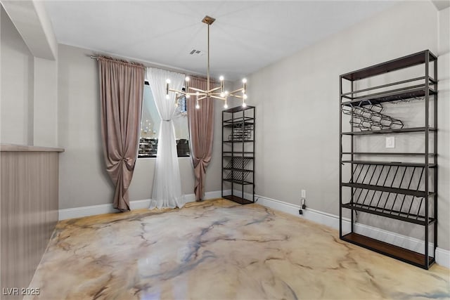 unfurnished dining area featuring concrete flooring, a notable chandelier, visible vents, and baseboards