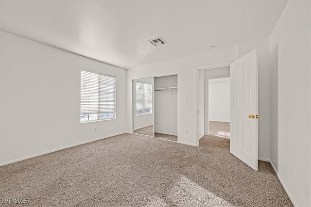 unfurnished bedroom featuring a closet, carpet flooring, and a textured ceiling