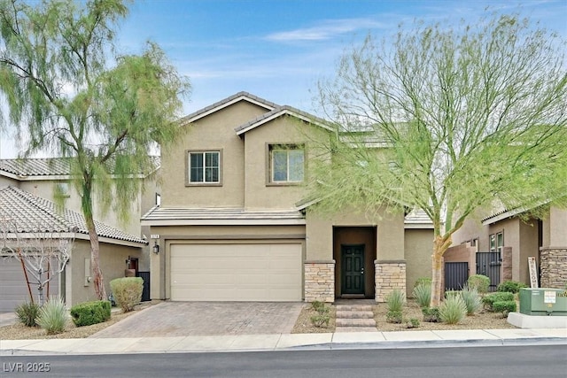 view of front of home featuring driveway, a garage, stone siding, a tiled roof, and stucco siding