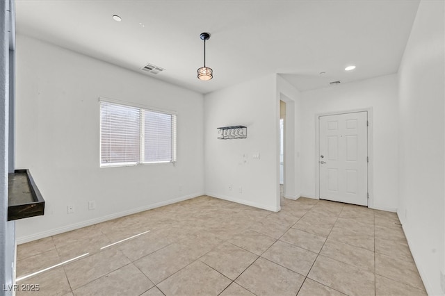 spare room with light tile patterned floors, visible vents, and baseboards