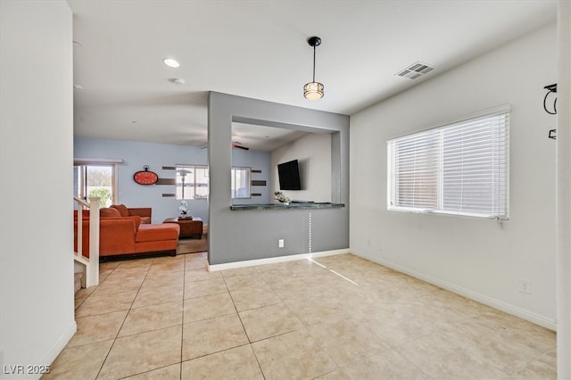 living area with light tile patterned floors, visible vents, and baseboards