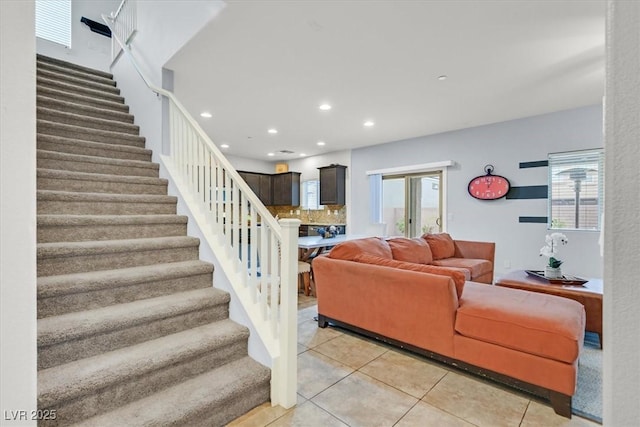 living room featuring stairway, light tile patterned flooring, and recessed lighting