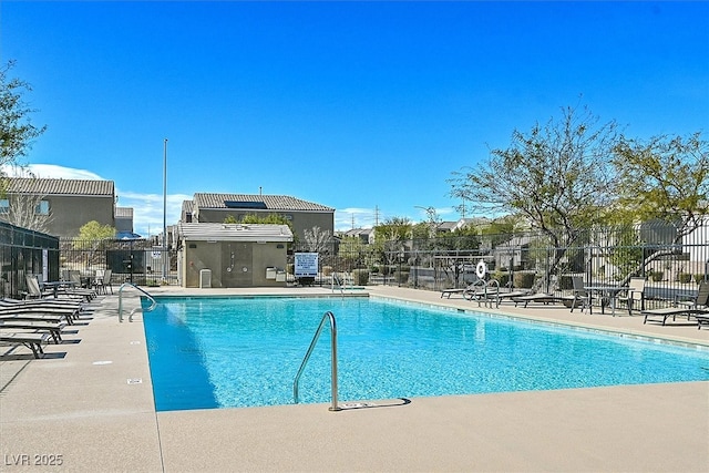 community pool with a patio and fence