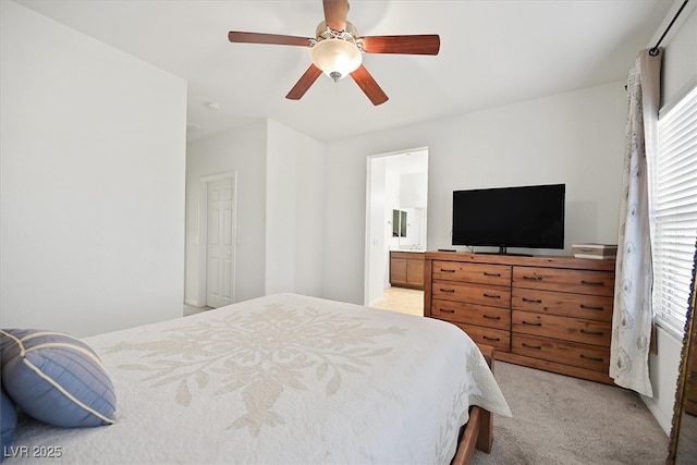 bedroom featuring light carpet, ceiling fan, multiple windows, and connected bathroom