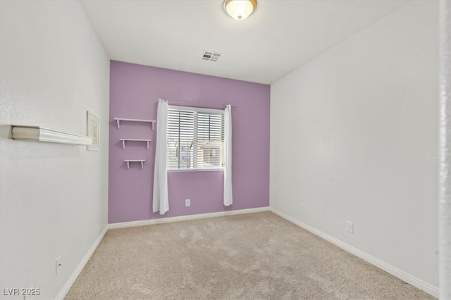 carpeted empty room featuring visible vents and baseboards