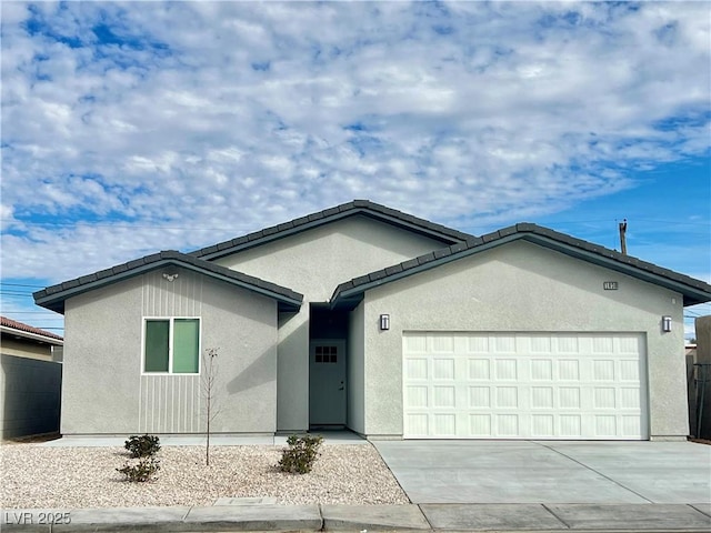 ranch-style house featuring a garage, concrete driveway, and stucco siding