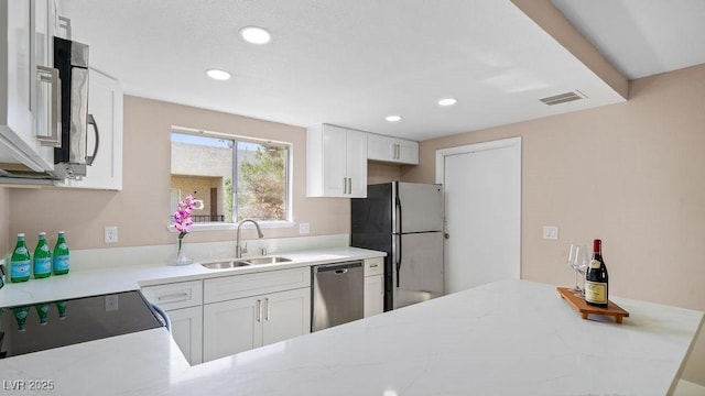 kitchen featuring sink, appliances with stainless steel finishes, and white cabinets