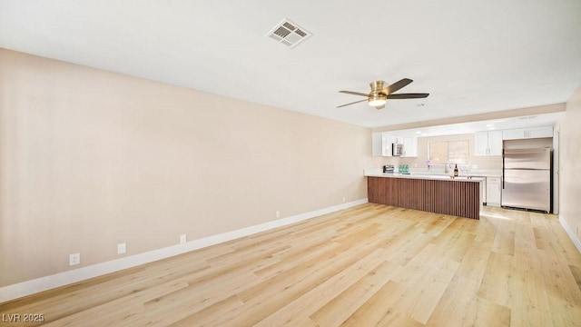 kitchen featuring light hardwood / wood-style floors, stainless steel appliances, ceiling fan, kitchen peninsula, and white cabinets