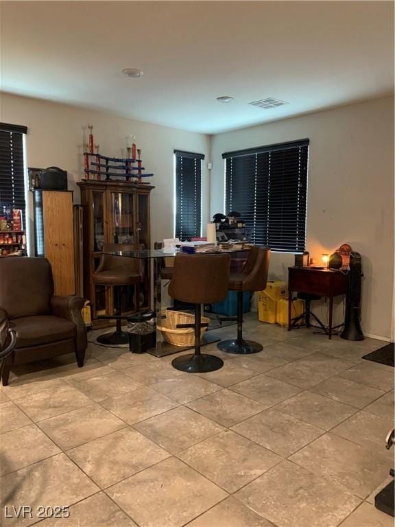 living area with visible vents and light tile patterned floors