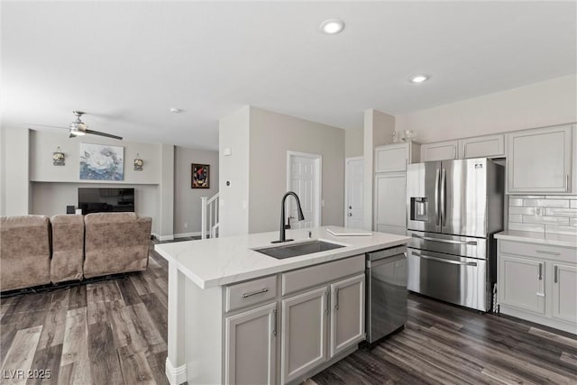 kitchen featuring a center island with sink, stainless steel appliances, dark hardwood / wood-style flooring, and sink