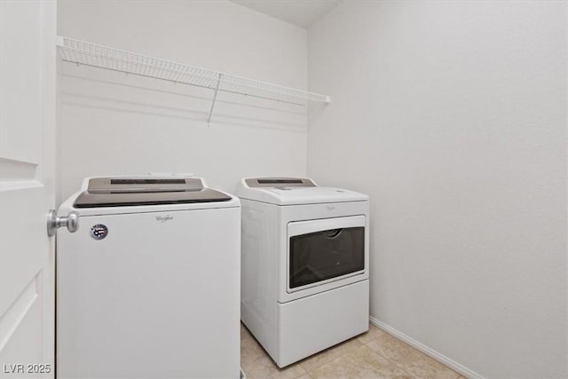 clothes washing area featuring light tile patterned flooring and washing machine and dryer