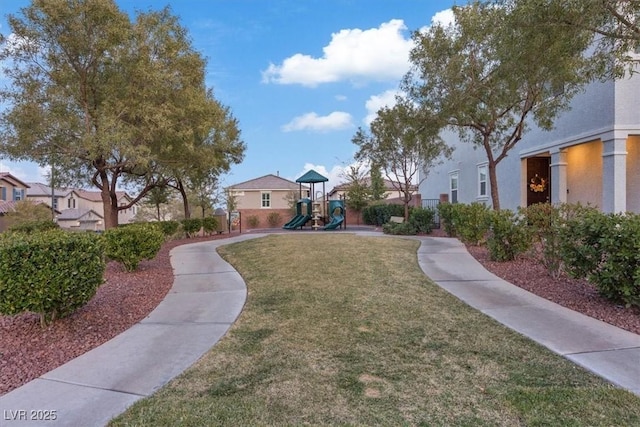 view of home's community featuring a lawn and playground community