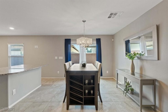 dining space with a notable chandelier and light tile patterned floors