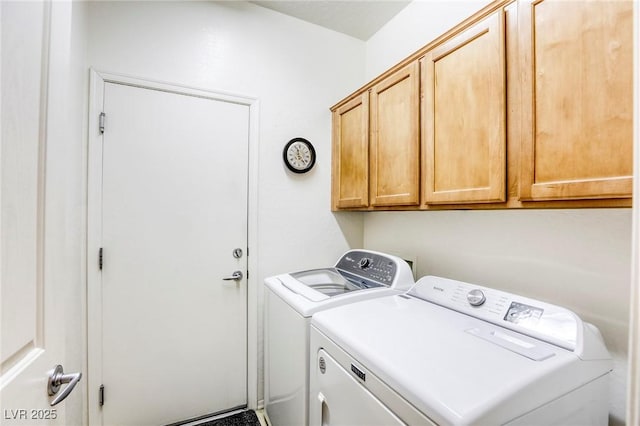 clothes washing area featuring separate washer and dryer and cabinets