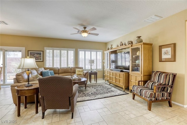 living room featuring a wealth of natural light and ceiling fan