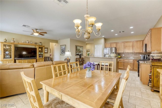 dining area featuring ceiling fan with notable chandelier