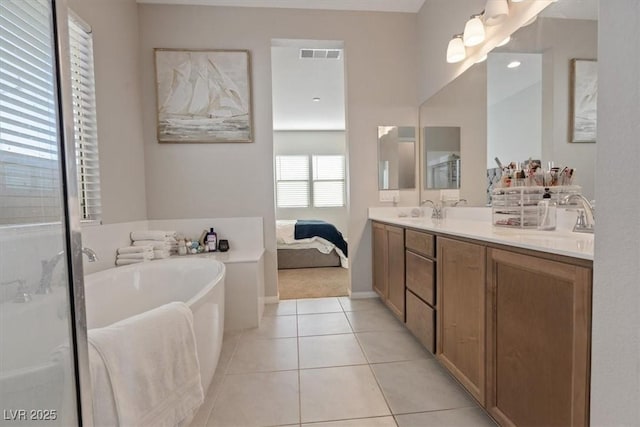 bathroom with tile patterned flooring, a bathtub, and vanity