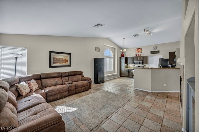 living room featuring lofted ceiling, light tile patterned flooring, and visible vents