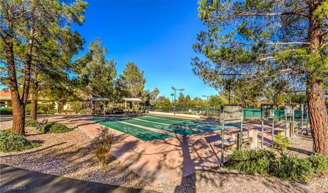 view of swimming pool with fence and shuffleboard