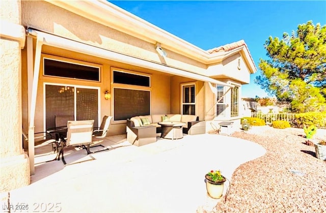 back of property featuring a patio area, outdoor lounge area, fence, and stucco siding