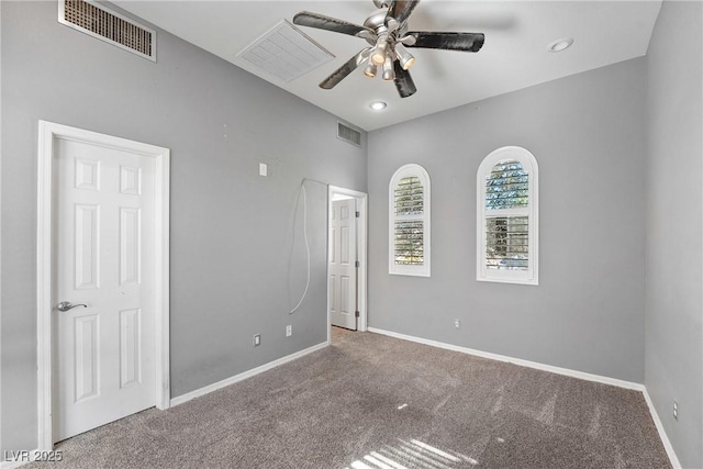 spare room featuring carpet flooring, visible vents, and baseboards