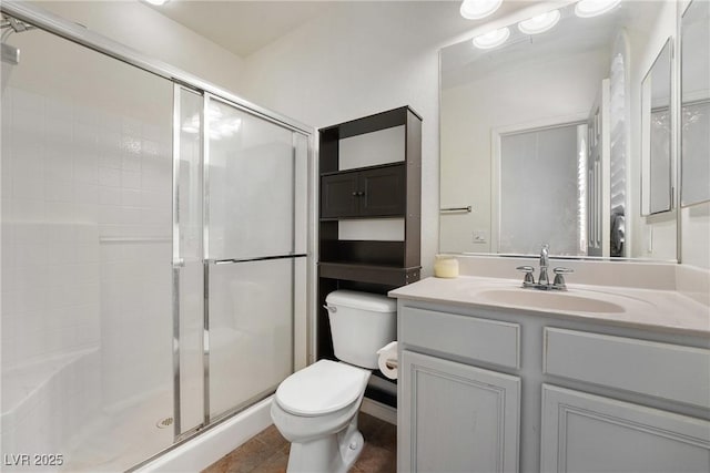 bathroom with toilet, a stall shower, and vanity