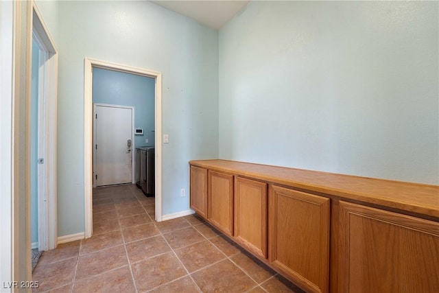 hall with light tile patterned flooring and baseboards