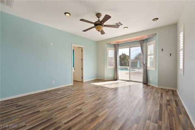 unfurnished room with visible vents, ceiling fan, baseboards, and wood finished floors