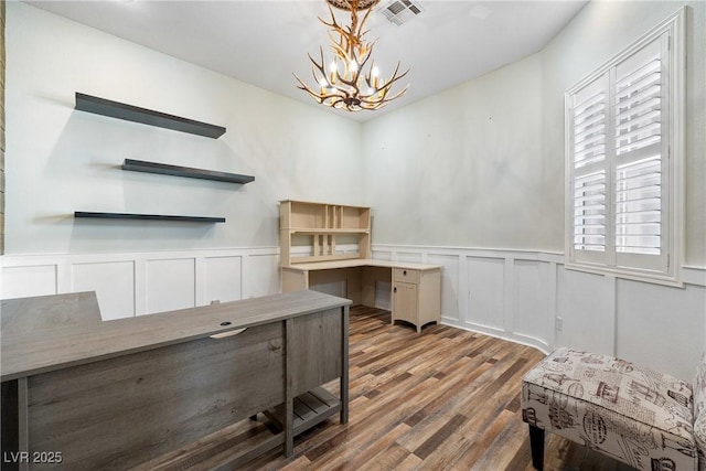 office with wainscoting, wood finished floors, visible vents, and a notable chandelier