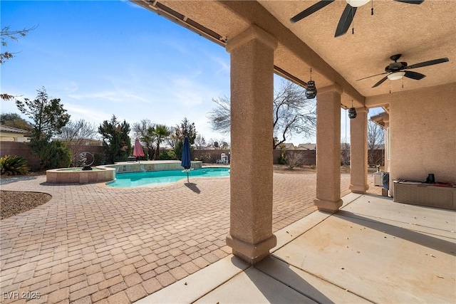 view of patio / terrace with a pool with connected hot tub and a fenced backyard