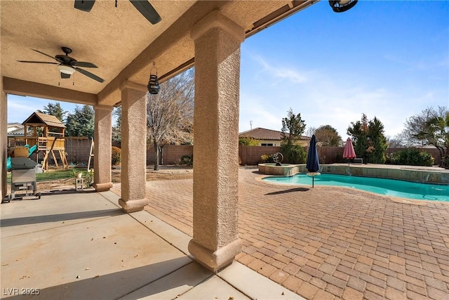 view of patio with a pool with connected hot tub, a fenced backyard, a playground, and ceiling fan