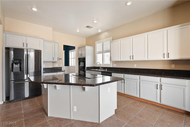 kitchen with a center island, white cabinets, a sink, and black appliances