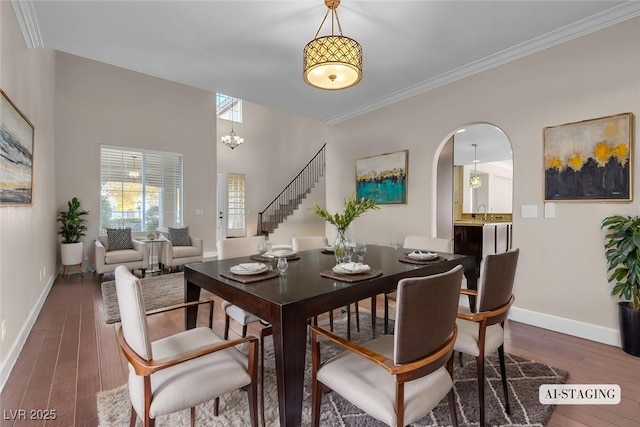 dining space with crown molding, an inviting chandelier, dark wood-type flooring, and sink