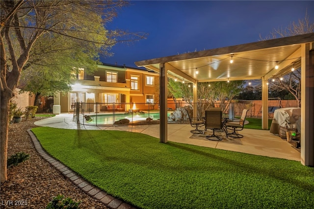 exterior space with a balcony, fence, a grill, a lawn, and a fenced in pool