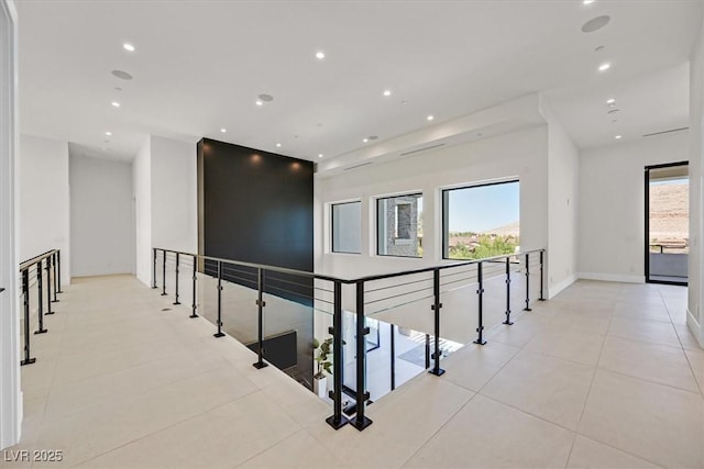 corridor featuring light tile patterned floors and a wealth of natural light