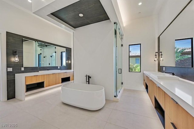 bathroom with tile patterned floors, separate shower and tub, a wealth of natural light, and vanity
