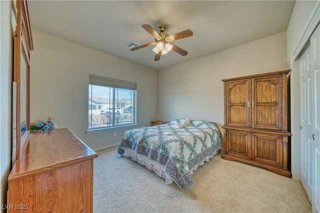 bedroom featuring ceiling fan, light carpet, and a closet