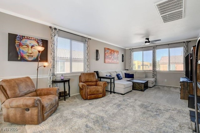 living room with ceiling fan, crown molding, carpet floors, and a wealth of natural light