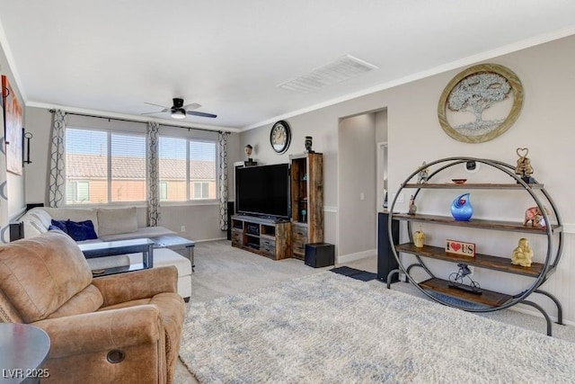 carpeted living room featuring ceiling fan and ornamental molding