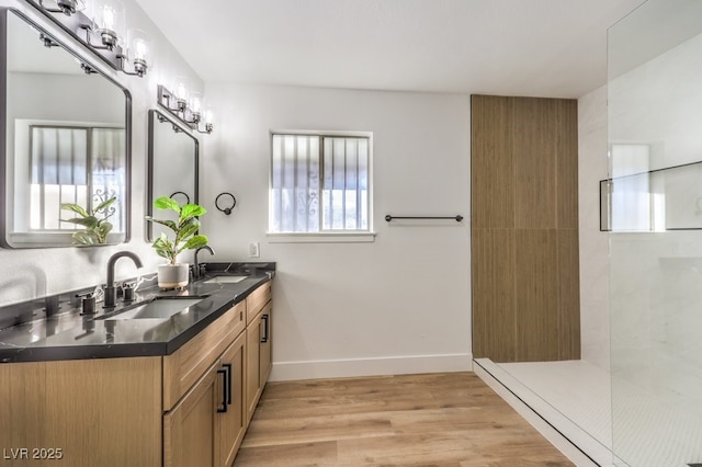 bathroom with vanity, hardwood / wood-style floors, and tiled shower