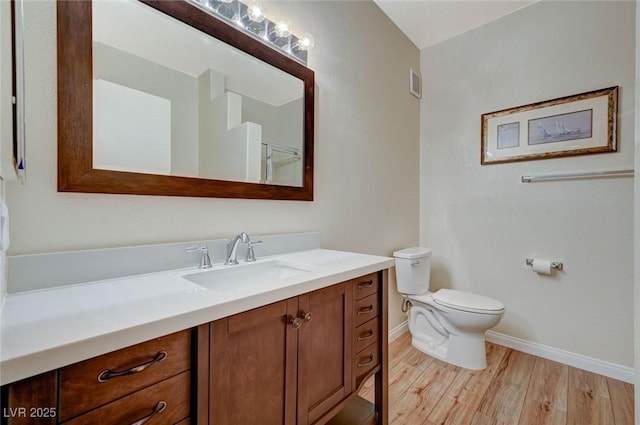 bathroom with wood-type flooring, vanity, and toilet