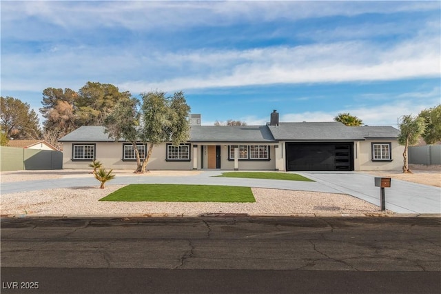 ranch-style house featuring a garage, driveway, fence, and stucco siding