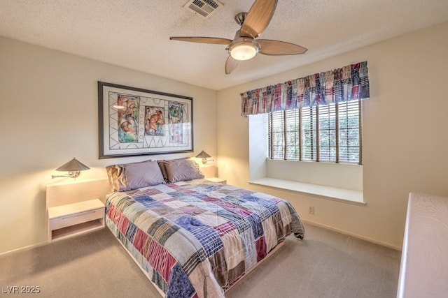 carpeted bedroom featuring a textured ceiling and ceiling fan