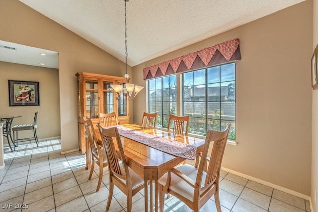 dining area with a textured ceiling, vaulted ceiling, a notable chandelier, and light tile patterned floors