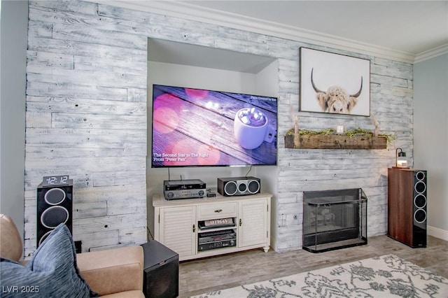 living room featuring ornamental molding, light wood-type flooring, and a large fireplace